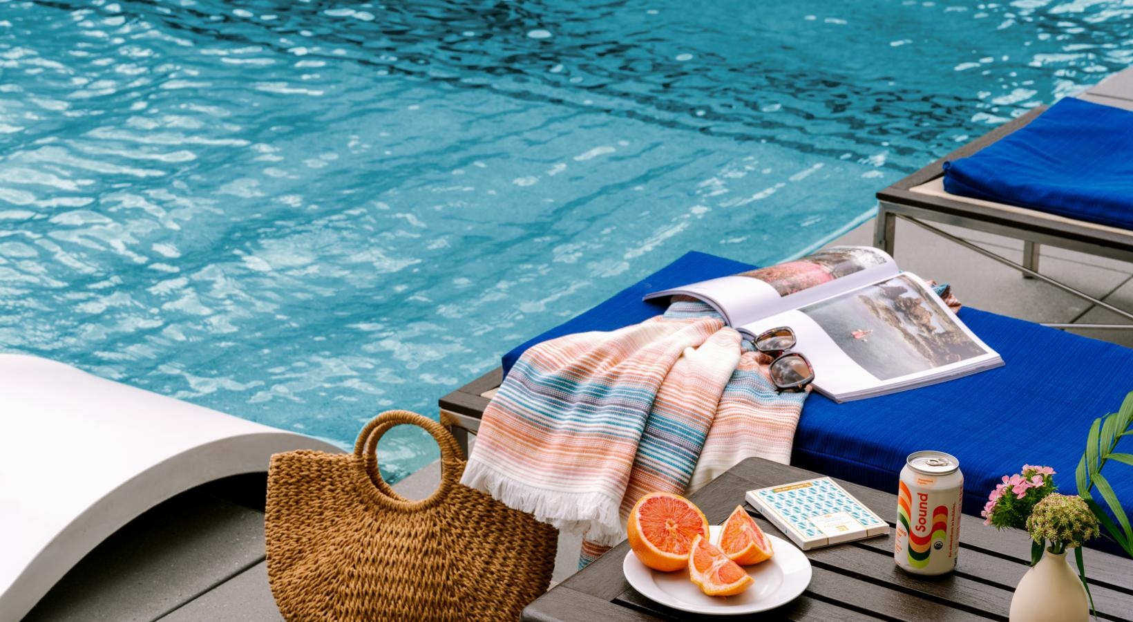 Resort-style swimming pool a table with a basket and a basket of food and a drink