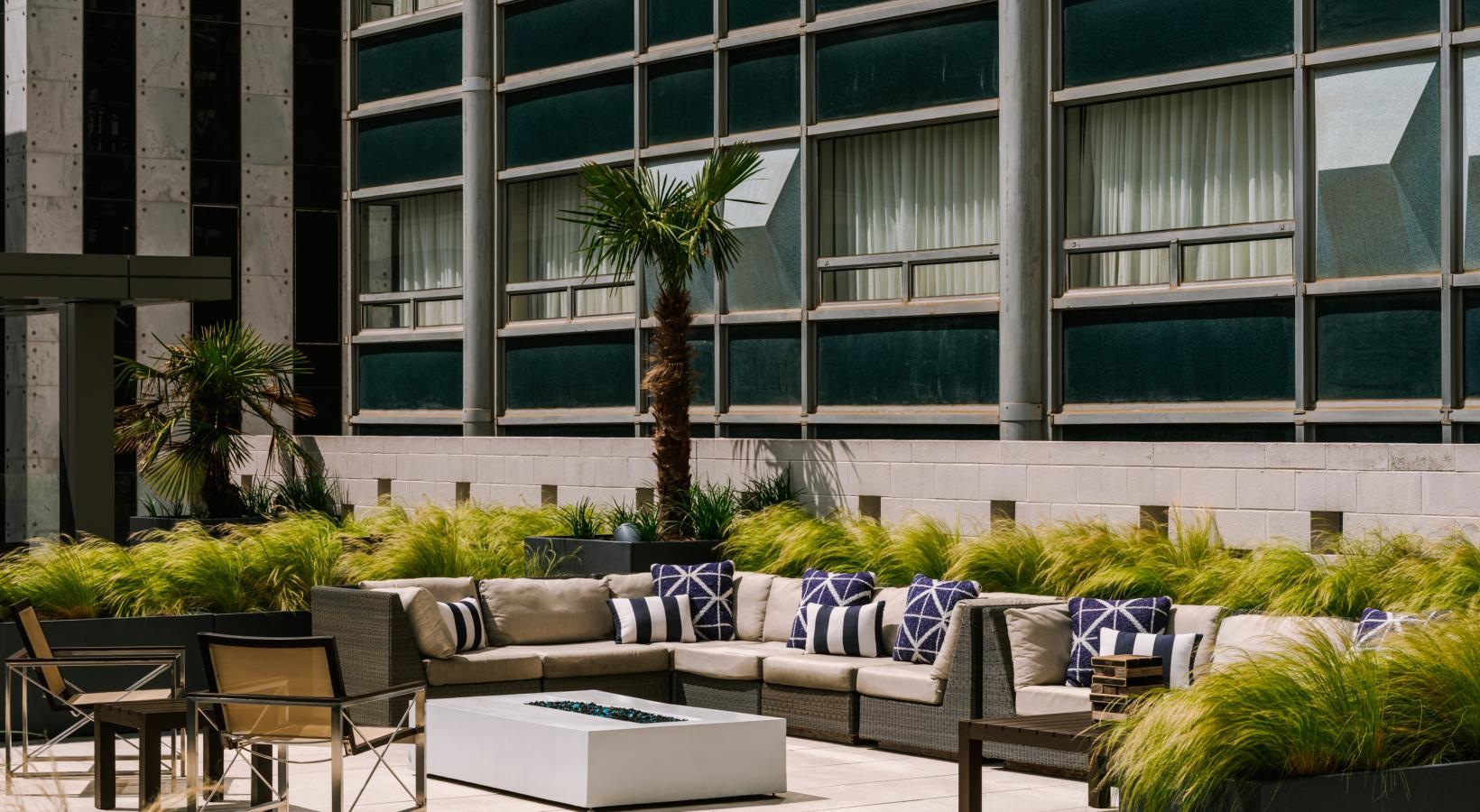 Everything within reach a patio with chairs and tables and plants in front of a building