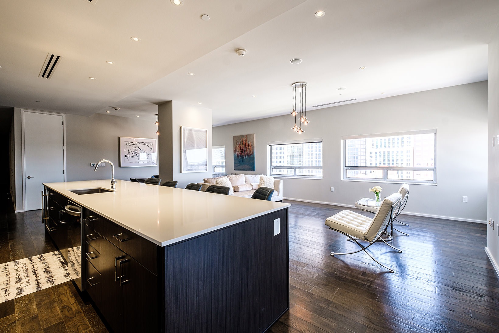 Kitchen kitchen island overlooking spacious living room with large windows